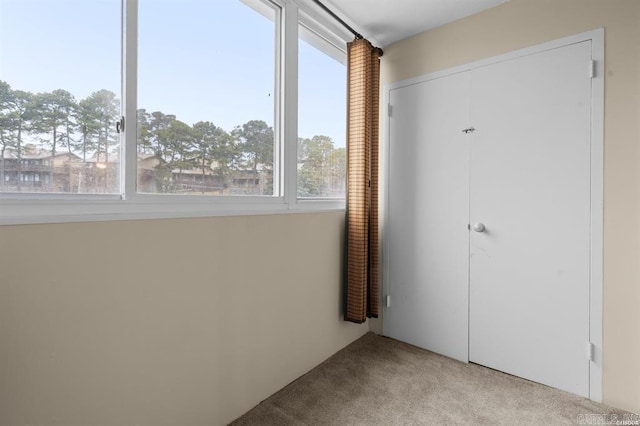 unfurnished bedroom featuring light colored carpet and a closet