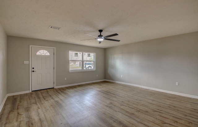 entryway featuring a textured ceiling, ceiling fan, and light hardwood / wood-style flooring