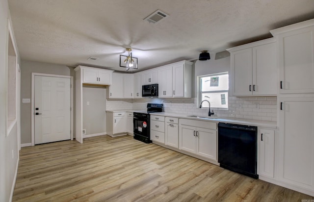 kitchen featuring white cabinetry, sink, backsplash, black appliances, and light wood-type flooring