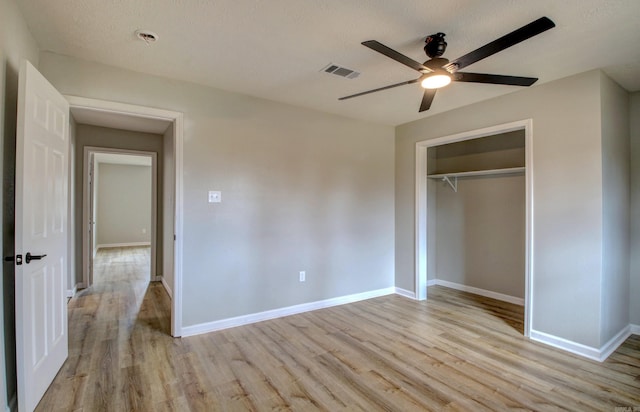 unfurnished bedroom with ceiling fan, light hardwood / wood-style floors, a closet, and a textured ceiling