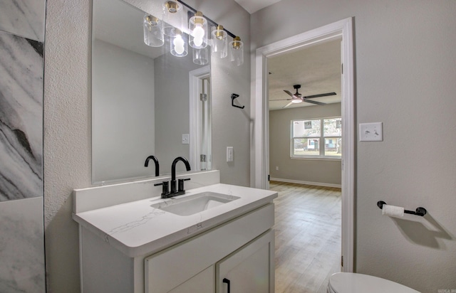 bathroom featuring ceiling fan, vanity, toilet, and hardwood / wood-style floors