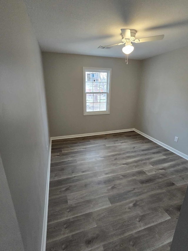 spare room with dark hardwood / wood-style floors and ceiling fan