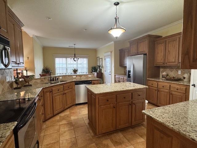 kitchen featuring appliances with stainless steel finishes, decorative light fixtures, kitchen peninsula, and sink