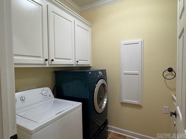 laundry area with separate washer and dryer, ornamental molding, and cabinets