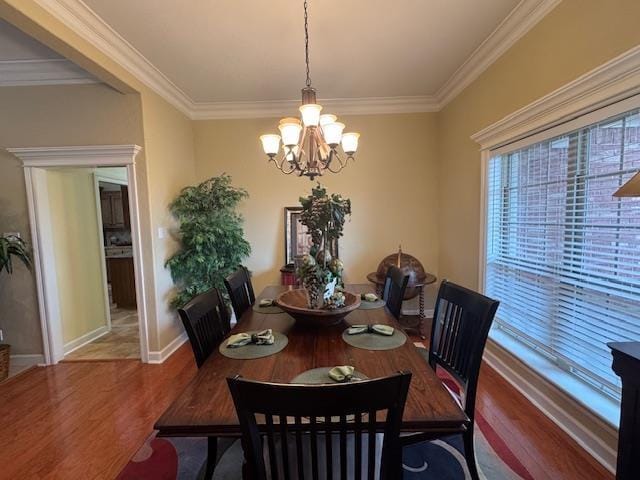 dining space with crown molding, wood-type flooring, and a chandelier