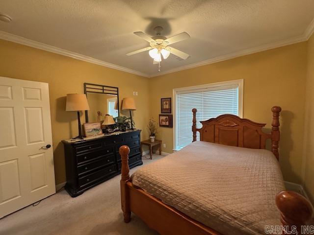 carpeted bedroom featuring crown molding, a textured ceiling, and ceiling fan