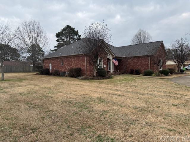 view of property exterior with central AC and a yard