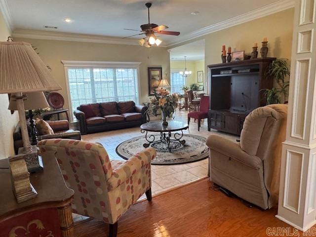 living room featuring crown molding, ceiling fan with notable chandelier, and hardwood / wood-style flooring