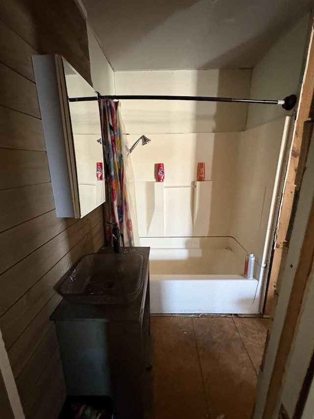 bathroom featuring sink, shower / tub combo, and wood walls