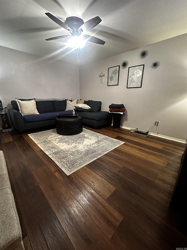 living room featuring dark wood-type flooring and ceiling fan