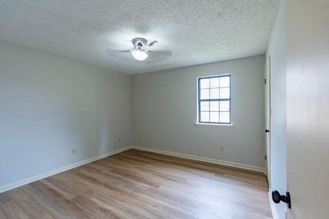 empty room with ceiling fan, light hardwood / wood-style floors, and a textured ceiling