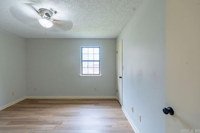 unfurnished room with ceiling fan, a textured ceiling, and light wood-type flooring