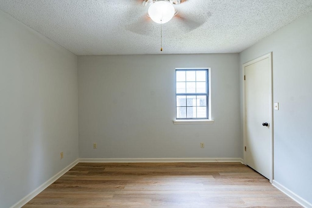 spare room with ceiling fan, light hardwood / wood-style floors, and a textured ceiling