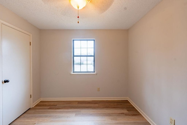 spare room featuring a textured ceiling and light hardwood / wood-style flooring