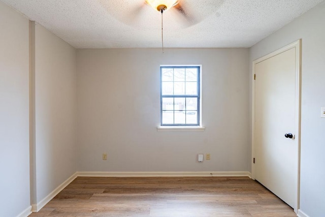 unfurnished room featuring a textured ceiling and light wood-type flooring