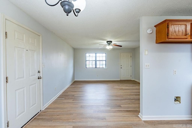 empty room featuring ceiling fan, a textured ceiling, and light wood-type flooring