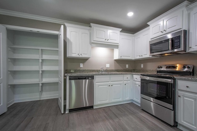 kitchen with stainless steel appliances, dark hardwood / wood-style floors, sink, and white cabinets