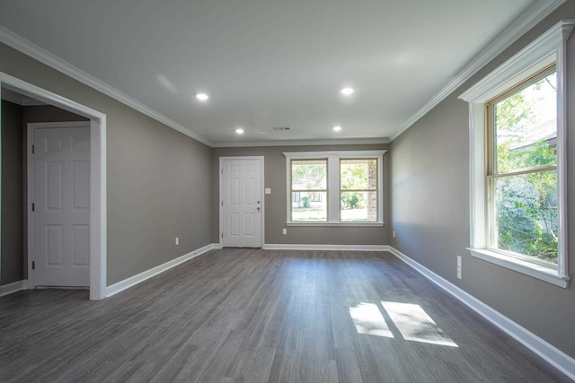 unfurnished room featuring crown molding, a healthy amount of sunlight, and dark wood-type flooring