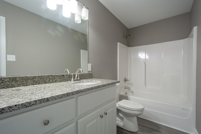 full bathroom featuring hardwood / wood-style flooring, vanity, washtub / shower combination, and toilet