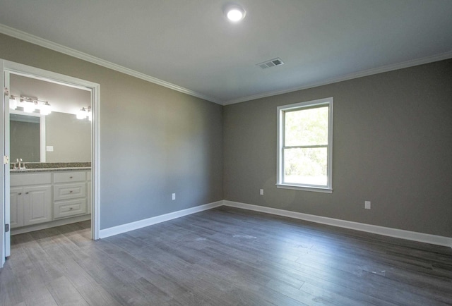 unfurnished bedroom featuring hardwood / wood-style flooring, crown molding, and sink