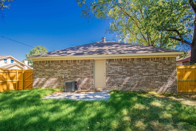 rear view of property featuring central AC unit, a patio area, and a lawn