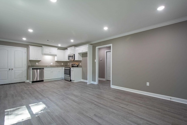 kitchen featuring white cabinetry, appliances with stainless steel finishes, crown molding, and light wood-type flooring