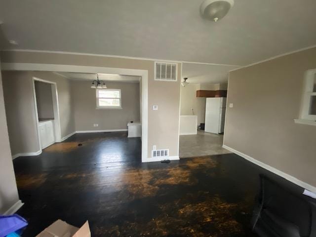 unfurnished living room featuring a notable chandelier