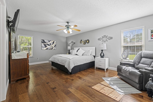 bedroom with dark hardwood / wood-style flooring, ceiling fan, and a textured ceiling