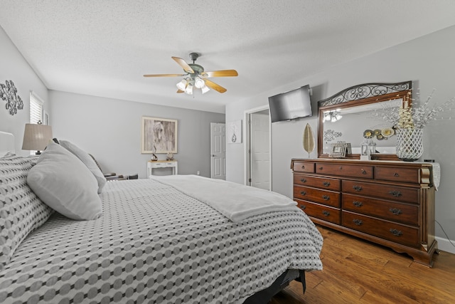 bedroom featuring hardwood / wood-style flooring, ceiling fan, and a textured ceiling