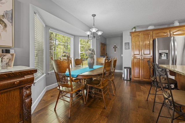 dining room featuring dark hardwood / wood-style floors, a textured ceiling, and an inviting chandelier