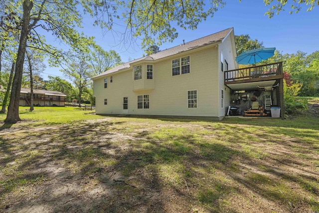 rear view of house featuring a deck and a lawn