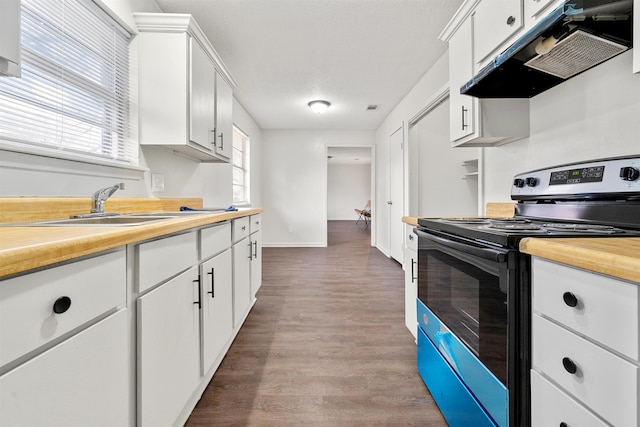 kitchen with sink, exhaust hood, stainless steel range with electric stovetop, hardwood / wood-style flooring, and white cabinets