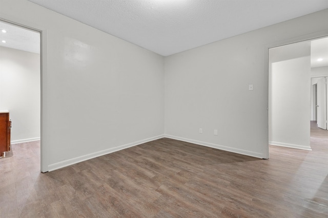 empty room with hardwood / wood-style flooring and a textured ceiling