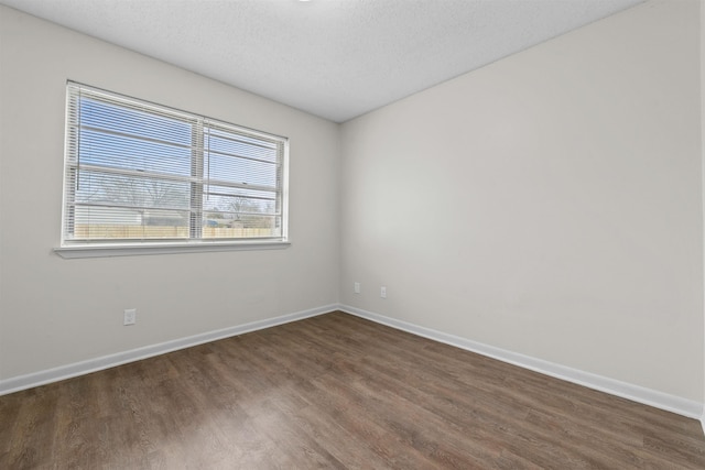 unfurnished room with dark hardwood / wood-style floors and a textured ceiling