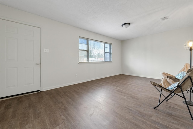 interior space featuring dark wood-type flooring and a textured ceiling