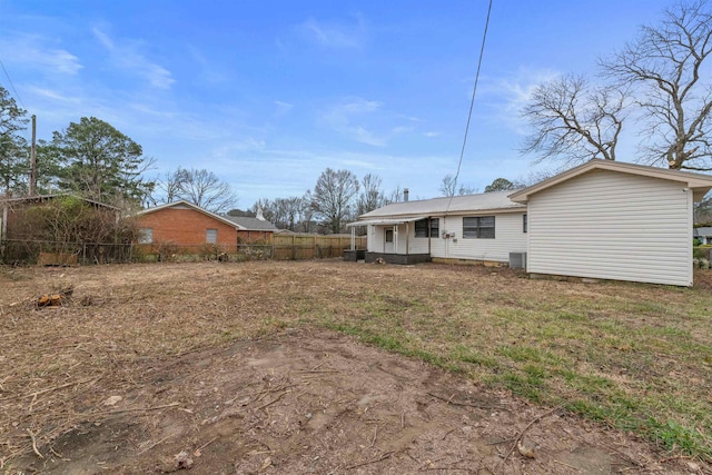 back of property featuring cooling unit and a yard