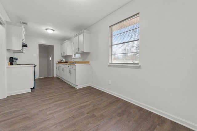 kitchen with electric stove, white cabinetry, hardwood / wood-style floors, butcher block counters, and a textured ceiling