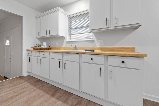 kitchen featuring white cabinetry, sink, and light wood-type flooring