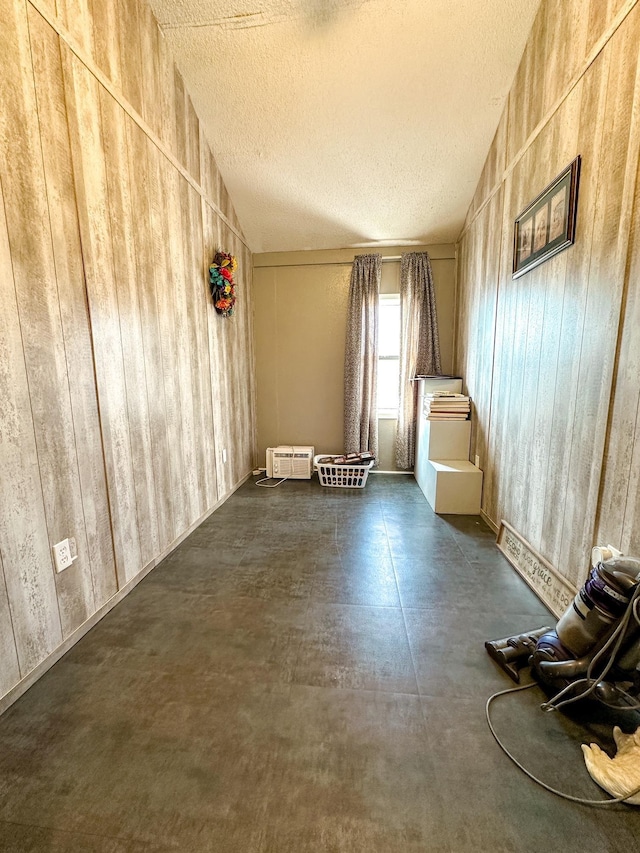 unfurnished room featuring vaulted ceiling and a textured ceiling