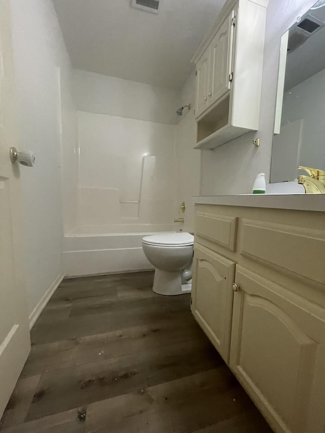 full bathroom featuring hardwood / wood-style flooring, shower / washtub combination, toilet, and vanity