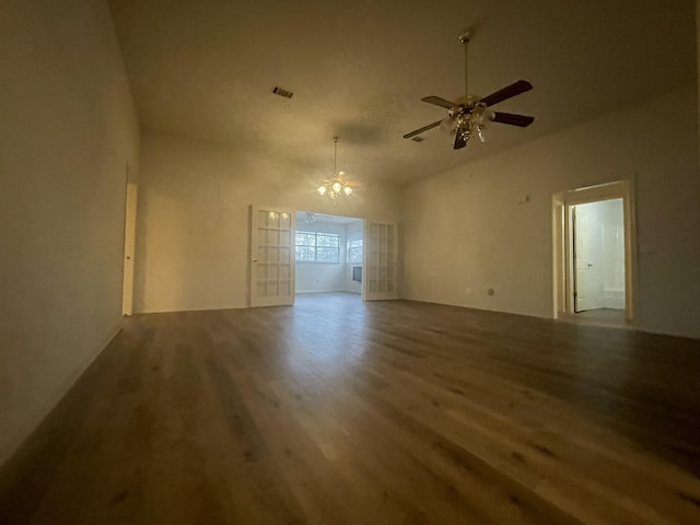 empty room with hardwood / wood-style flooring and ceiling fan with notable chandelier