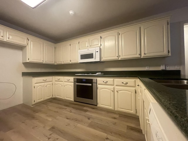 kitchen featuring white cabinetry, black electric cooktop, stainless steel oven, and light hardwood / wood-style floors