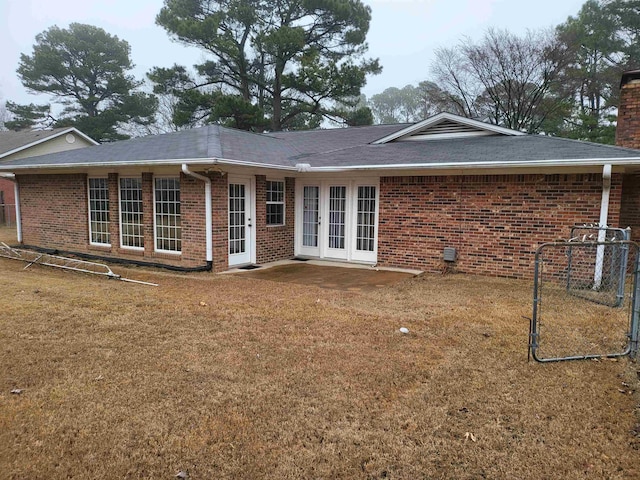 rear view of property with a lawn and french doors