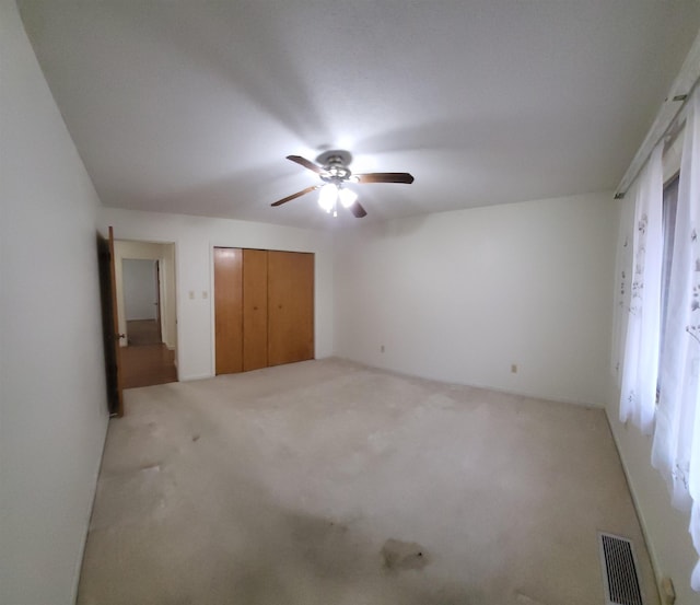 unfurnished bedroom featuring ceiling fan, carpet flooring, and a closet