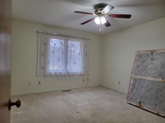 carpeted spare room featuring ceiling fan