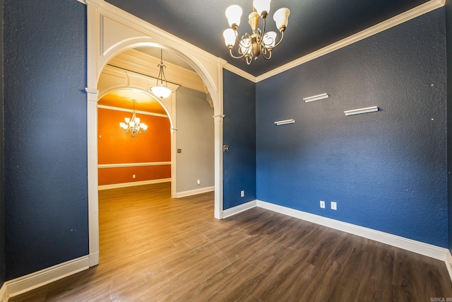 unfurnished room with crown molding, hardwood / wood-style floors, and a notable chandelier