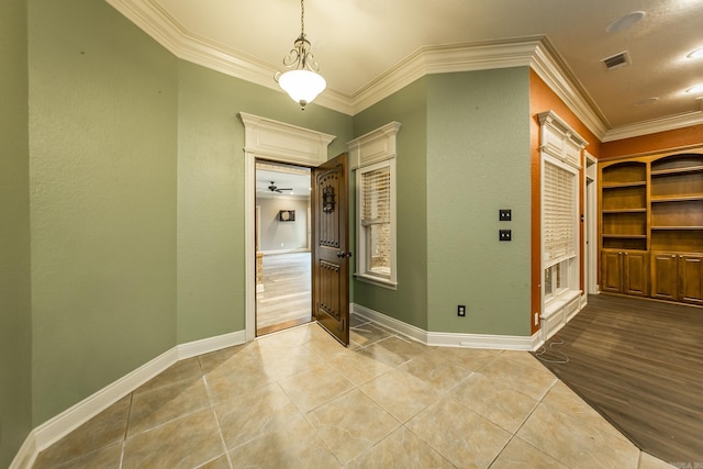 interior space with crown molding and light tile patterned floors