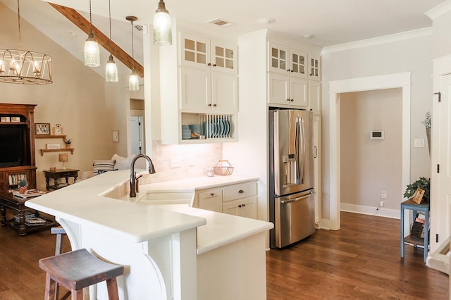 kitchen with pendant lighting, sink, a kitchen bar, stainless steel fridge with ice dispenser, and kitchen peninsula