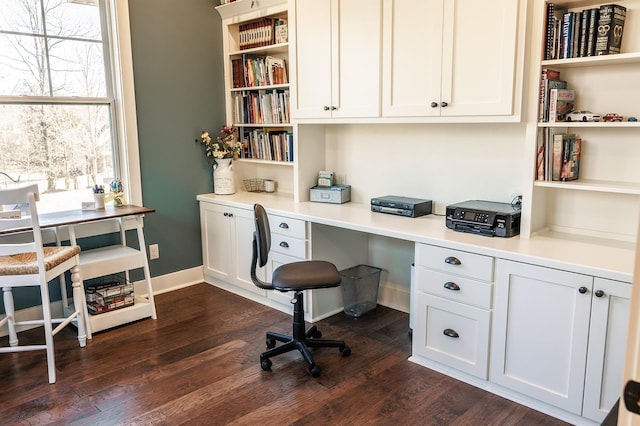 office area featuring dark hardwood / wood-style flooring and built in desk