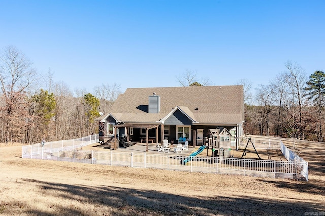 rear view of property with a playground and a patio area